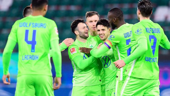 Die Spieler des VfL Wolfsburg jubeln und umarmen Josip Brekalo, der den Siegtreffer erzielt hat.  