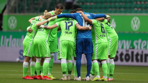 Die Spieler des VfL Wolfsburgs bilden einen Mannschaftskreis vor dem Spiel.