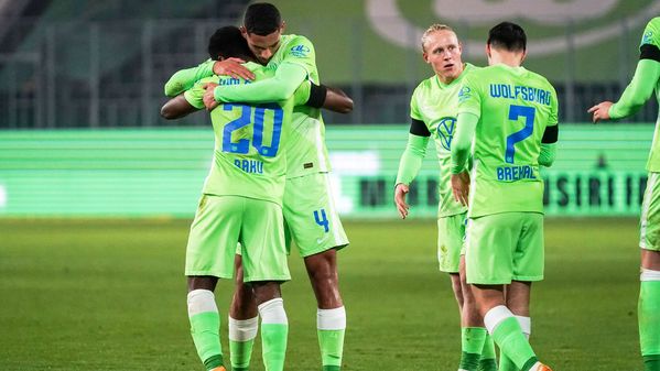 Die Spieler des VfL Wolfsburg umarmen sich vor Freude.