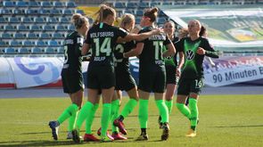 Die Spielerinnen des VfL Wolfsburg versammeln sich, nehmen sich in die Arme und bejubeln einen Treffer.