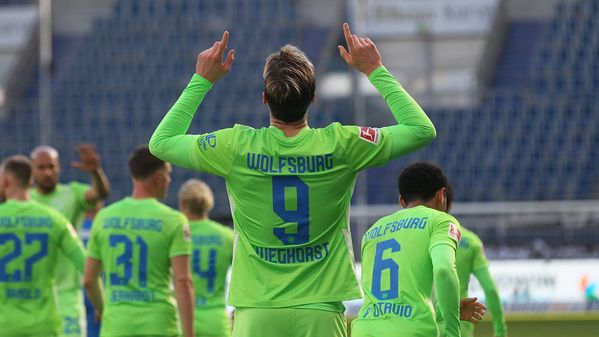 VfL-Wolfsburg-Spieler Wout Weghorst ist von hinten zu sehen. Er zeigt mit den Fingern in den Himmel und jubelt über seinen Treffer.
