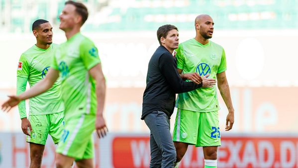 VfL-Wolfsburg-Trainer Oliver Glasner und John Brooks stehen nach dem Spiel beisammen, reden und klatschen sich ab.