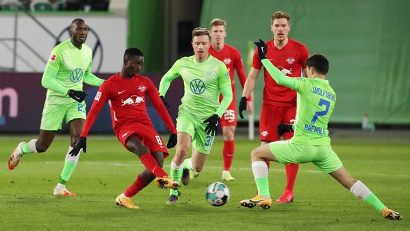 Die beiden VfL Wolfsburg-Spieler Yannick Gerhardt und Josip Brekalo kämpfen mit einem Gegenspieler um den Ball.