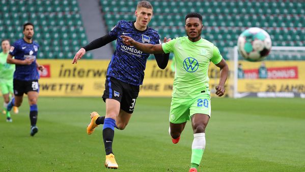 VfL-Wolfsburg-Spieler Ridle Baku läuft zusammen mit einem Gegenspieler hinter dem Ball her.