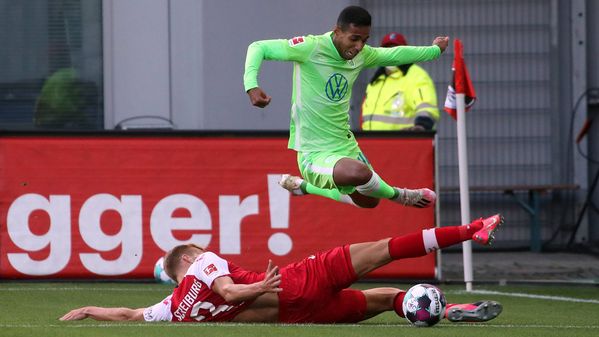 VfL-Wolfsburg-Spieler Joao Victor springt über einen Gegenspieler.