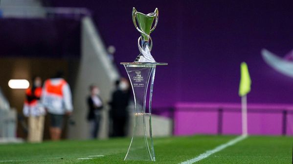 Der Pokal der UEFA Womens Champions League auf einem Podest am Spielfeldrand.