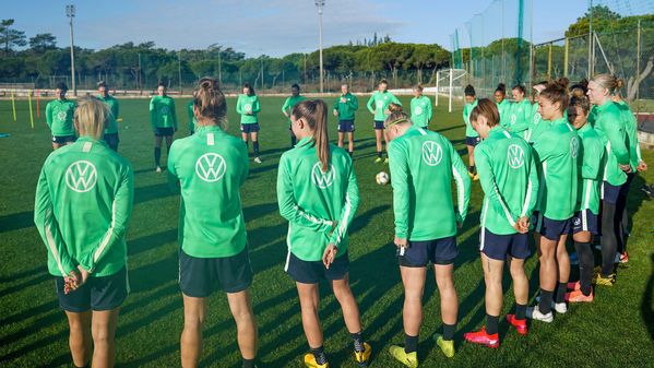 Das gesamte Frauen-Bundesligateam des VfL Wolfsburg zu Beginn des Trainings im Kreis aufgestellt unter Portugals Sonne.