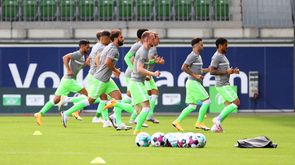 Die Spieler des VfL Wolfsburg laufen sich warm.