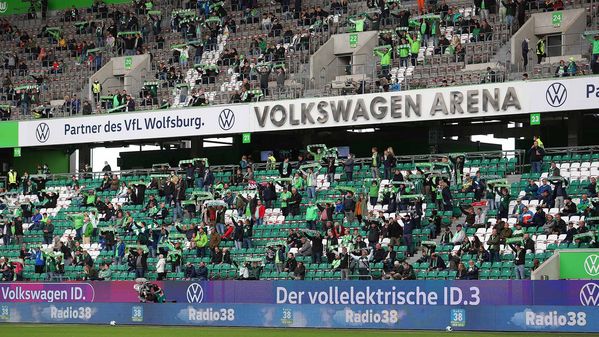 Die Fans auf den Rängen halten ihre VfL-Wolfsburg-Schals hoch.