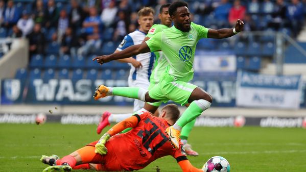 VfL Wolfsburg-Spieler John Yeboah springt über den Torwart.