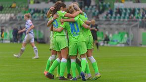 Die Spielerinnen des VfL Wolfsburg jubeln und umarmen sich in einem Kreis. 