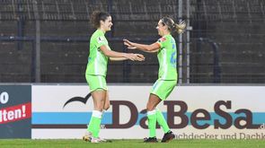 VfL Wolfsburg Spielerinnen Dominique Janssen und Lena Goeßling klatschen sich mit beiden Händen ab.