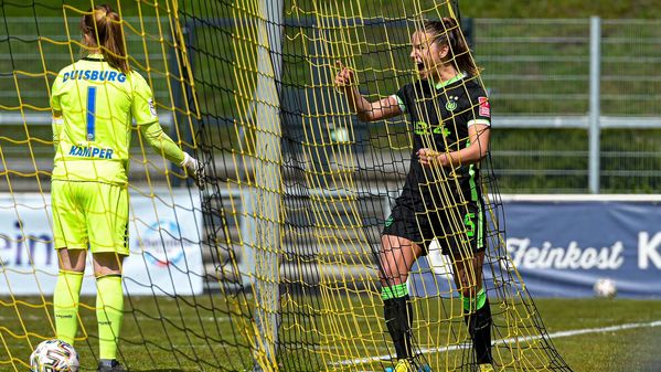 Die VfL-Wolfsburg-Spielerin Lena Oberdorf steht im Netz des Tors und jubelt.