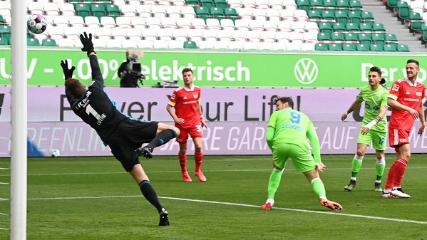 VfL Wolfsburg-Spieler Wout Weghorst duckt sich weg und Union-Keeper Andreas Luthe springt zum Ball.