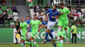 Der VfL-Wolfsburg-Stürmer Daniel Ginczek und ein Rostock-Spieler springen in die Höhe und kämpfen um den Kopfball.