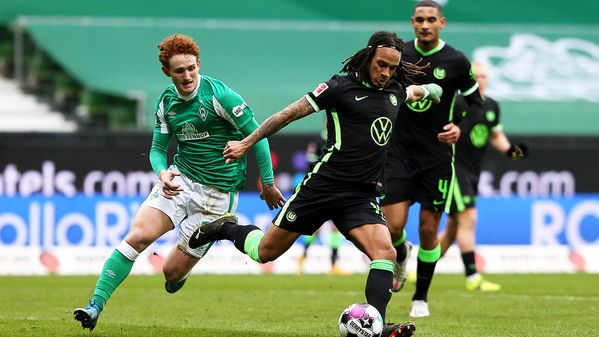 Mbabu spielt, verfolgt von einem Gegenspieler, den Ball im Bundesliga Spiel der Wölfe gegen Werder Bremen.