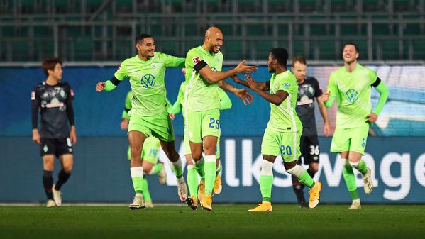 Die VfL-Wolfsburg Profis John Brooks, MaxenceLacroix und Ridle Baku jubeln nach einen Treffer und klatschen sich ab.