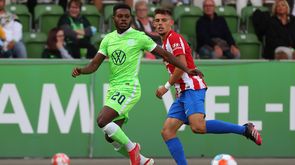 Der VfL-Wolfsburg-Spieler Ridle Baku im Laufduell mit Atletico-Spieler Joao Felix.