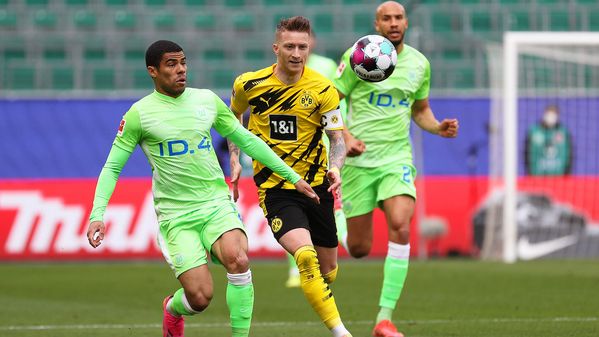 Der VfL-Wolfsburg-Spieler Paulo Otavio und BVB-Spieler Marco Reus versuchen den Ball mit der Brust anzunehmen.