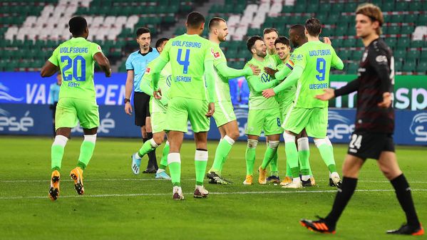 Die Spieler des VfL Wolfsburg jubeln und umarmen Josip Brekalo, der den Siegtreffer erzielt hat. 