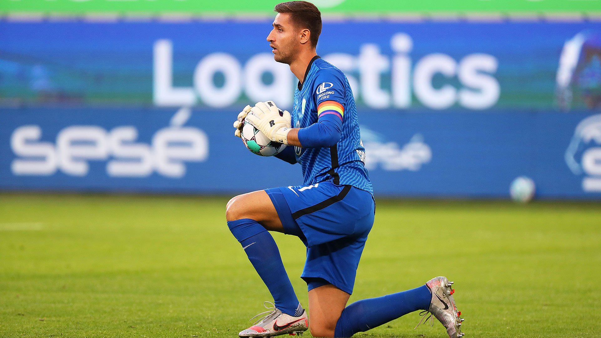 Koen Casteels kniet auf dem Feld und hat den Ball in den Händen | VfL Wolfsburg.