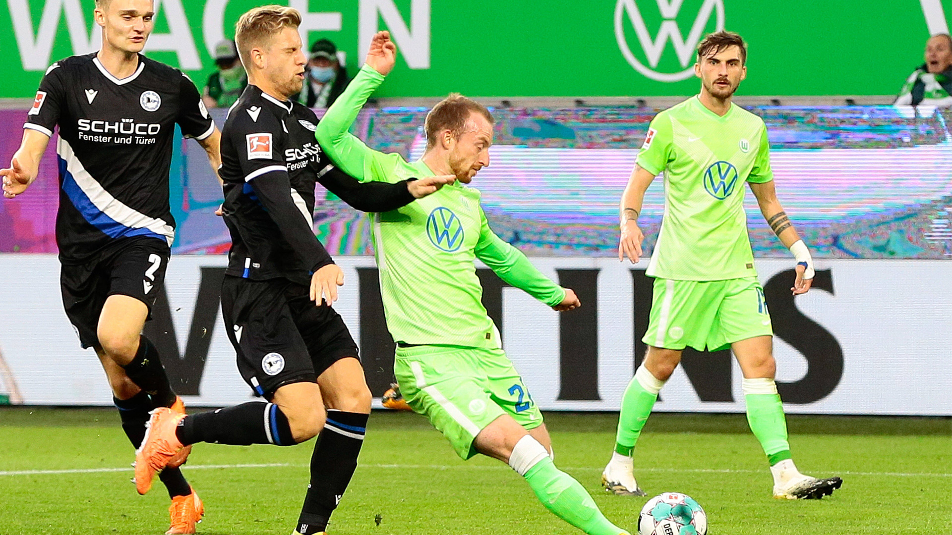 Der Wolfs Maximilian Arnold schießt den Ball im Zweikampf mit einem Spieler von Bielefeld.