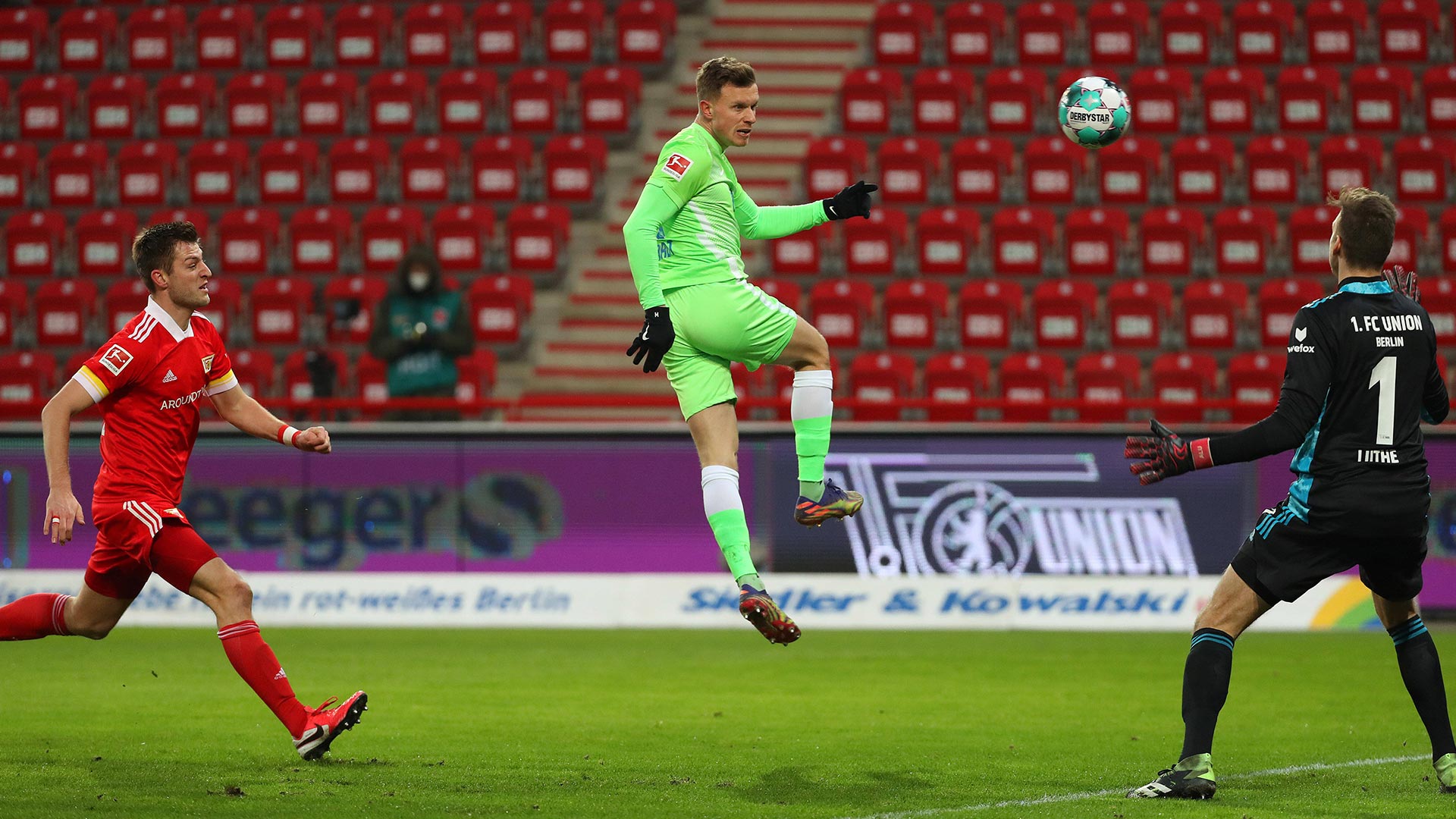 Der VfL Wolfsburg Spieler Gerhardt springt in die Luft um den Ball zu erreichen.
