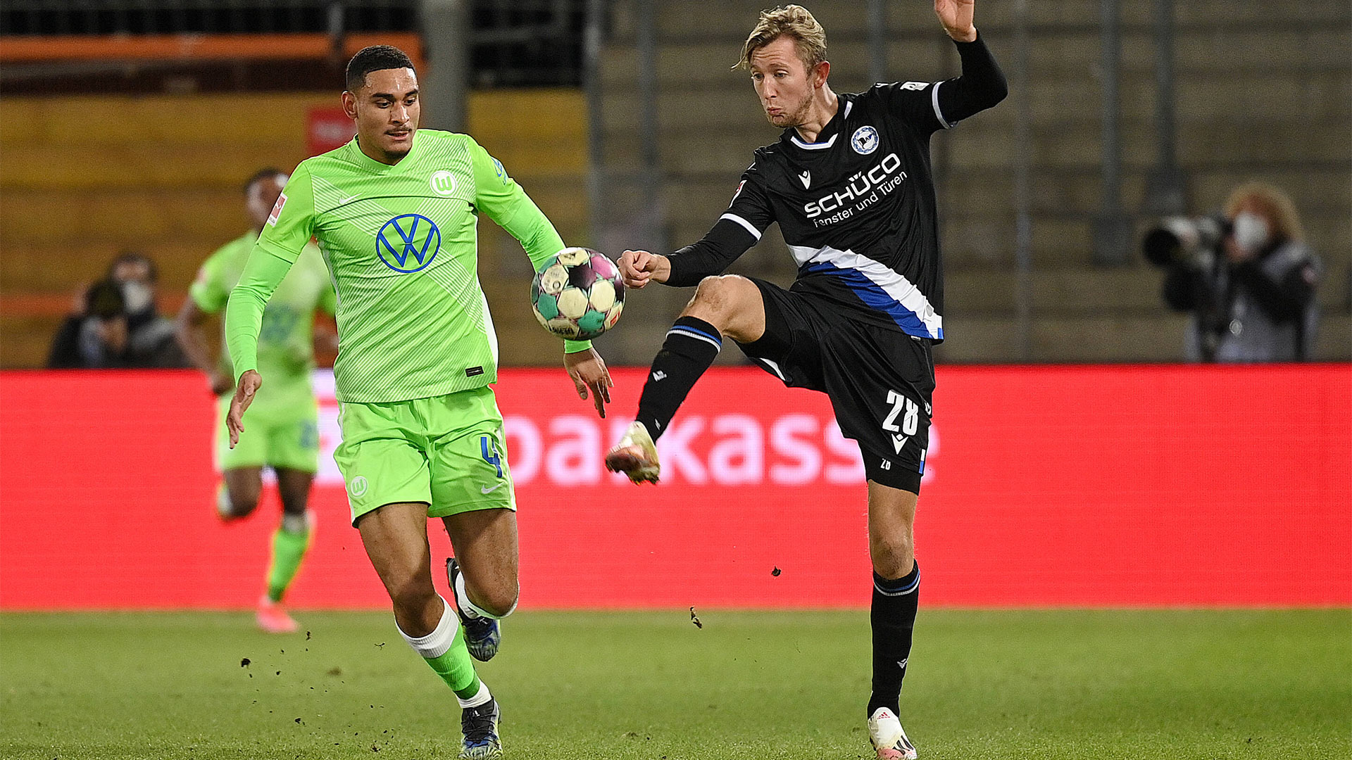 Ein Spieler des VfL Wolfsburg im Duell mit einem Gegenspieler.